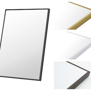 Op de afbeelding: Een rechthoekige spiegel met een zwart frame. Extra afbeeldingen tonen close-ups van de spiegelrand in goud, wit en donkerbruin. Het reflecterende oppervlak van de spiegel is helderwit.