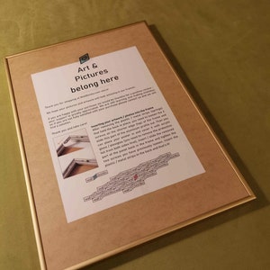 May include: A framed instruction sheet with a gold frame and a white background. The text explains how to insert artwork or photos into the frame. The text includes the words "Art & Pictures belong here".