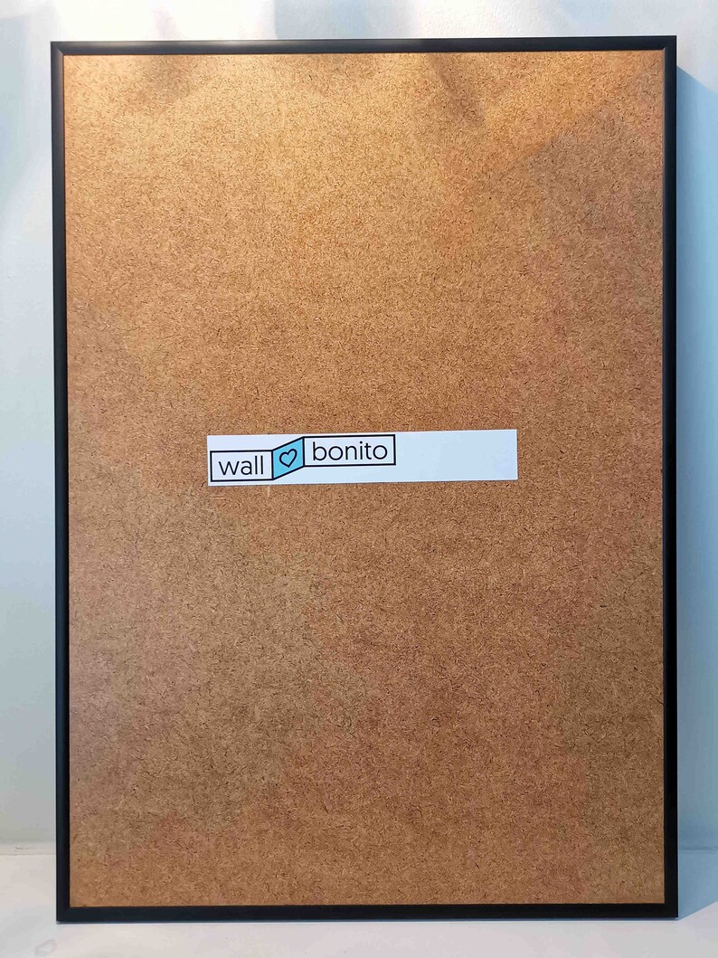 May include: A black framed corkboard with a white sticker that says "wall &hearts; bonito".