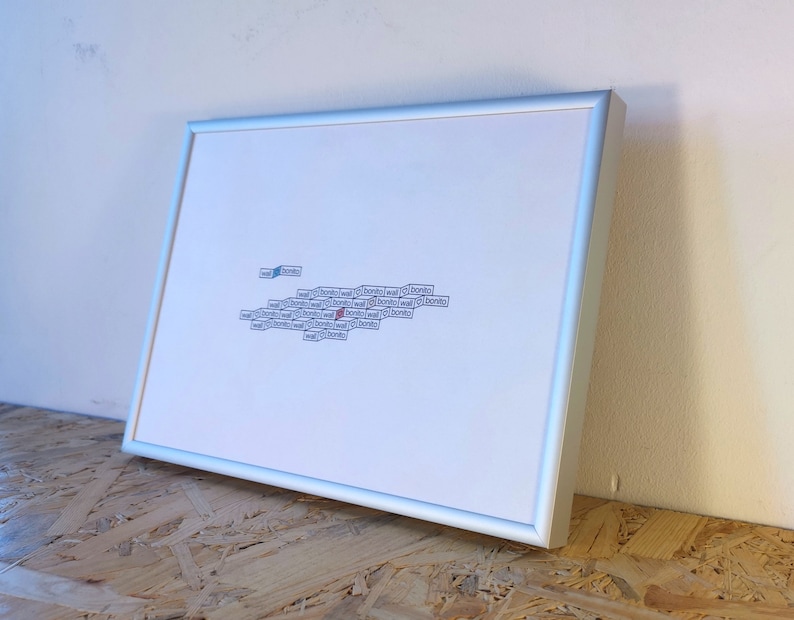 May include: A framed white print with a cluster of small, rectangular, blue and red paper scraps with text on them. The text on the scraps is mostly illegible.
