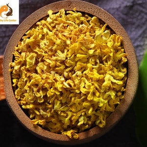 May include: A wooden bowl filled with dried yellow flower petals. The petals are loose and appear to be dried for tea or herbal remedies.