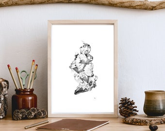 May include: A black and white line drawing of a stack of books in a minimalist style framed in a light wood frame. The frame is sitting on a wooden table with other decorative items.