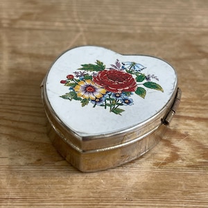 Vintage retro heart-shaped metal pill box with floral lid