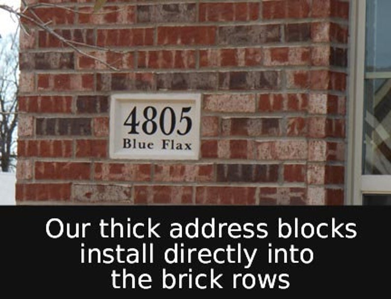 May include: A rectangular address plaque with the number "4805" and the words "Blue Flax" in black lettering. The plaque is set against a red brick wall. The text "Our thick address blocks install directly into the brick rows" is at the bottom.