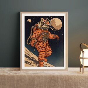 May include: A framed illustration of a tiger wearing a space suit and helmet, walking on the moon. The background is a dark blue space with stars and planets.