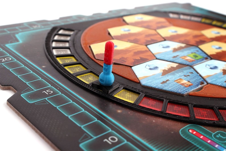 May include: A close-up of a game board with a red and blue temperature slider. The slider is set to -4 degrees. The board is made of black plastic and has a futuristic design.