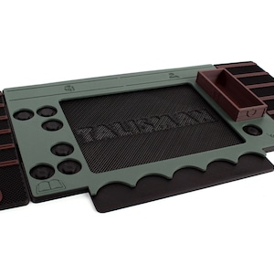 Pu&ograve; includere: Un tappetino da gioco verde e nero con la parola "remarkable" stampata su di esso. Il tappetino ha una variet&agrave; di scomparti e slot per pezzi di gioco e carte.