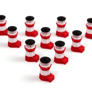 May include: A group of nine miniature red and white lighthouses with black tops arranged in a triangle shape on a white surface.