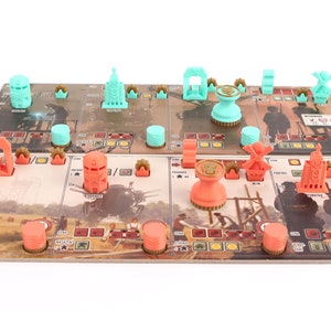Op de afbeelding: Een spelbord met verschillende gekleurde stukken en tokens. Het bord is gemaakt van karton en heeft een bruin en wit ontwerp. De stukken zijn gemaakt van plastic en zijn in verschillende kleuren, waaronder rood, blauw en groen.