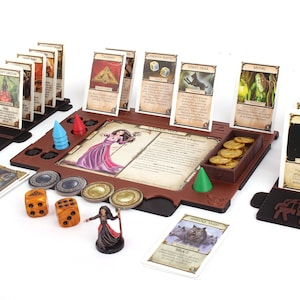 Pu&ograve; includere: Un tabellone da gioco in legno marrone con una variet&agrave; di carte, dadi e pedine. Il tabellone presenta un'area centrale con una carta personaggio e una descrizione di testo. Ci sono anche diverse aree pi&ugrave; piccole per contenere carte, dadi e pedine. Il gioco &egrave; pronto per essere giocato, con carte e pedine in posizione.