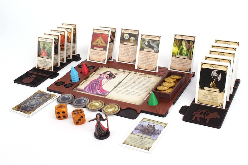 Pu&ograve; includere: Un tabellone da gioco in legno marrone con una variet&agrave; di carte, dadi e pedine. Il tabellone presenta un'area centrale con una carta personaggio e una descrizione di testo. Ci sono anche diverse aree pi&ugrave; piccole per contenere carte, dadi e pedine. Il gioco &egrave; pronto per essere giocato, con carte e pedine in posizione.