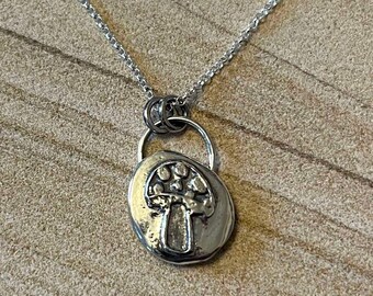 May include: A silver chain necklace with a silver mushroom pendant. The pendant is round and features a detailed mushroom design.
