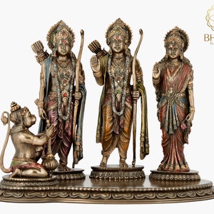 May include: A bronze statue of the Hindu deities Rama, Sita, and Hanuman. Rama and Sita are standing, while Hanuman is kneeling. The statue is decorated with colorful paint and jewels.