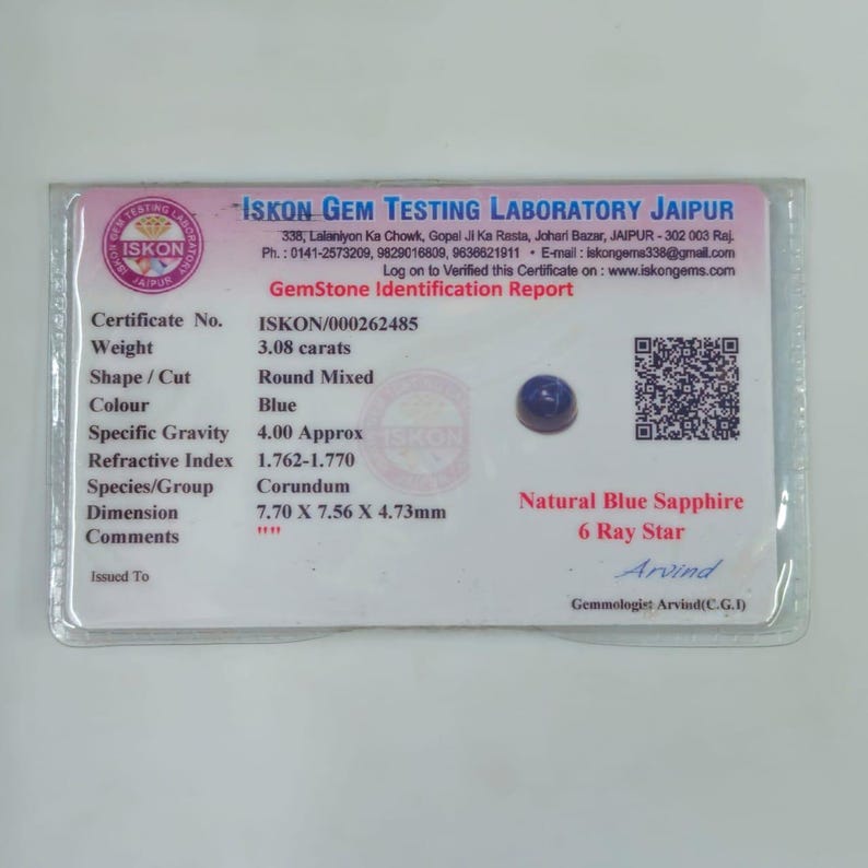 May include: A blue, round-mixed cut natural sapphire gemstone, weighing 3.08 carats, with a 6-ray star effect. The gemstone is accompanied by a GemStone Identification Report from ISKON GEM TESTING LABORATORY JAIPUR.