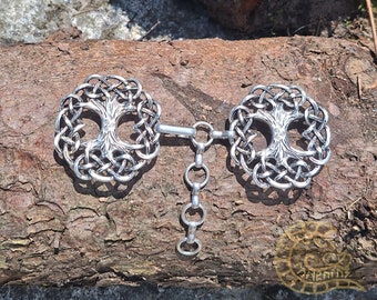 May include: A silver Celtic knotwork tree of life design with a chain connecting two circular pendants. The pendants are detailed with a tree of life design.