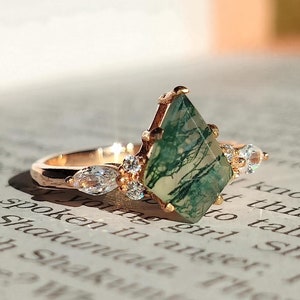 Könnte beinhalten: Ein Ring aus Roségold mit einem grünen Moosachat-Edelstein und kleinen klaren Zirkonia-Steinen.