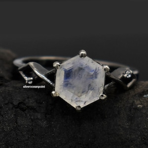 May include: A silver ring with a hexagonal moonstone set in a twisted band. The moonstone has a blue sheen.