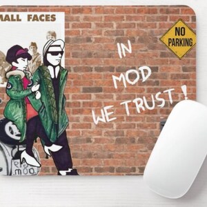 May include: A mouse pad with a brick wall background and a cartoon illustration of two people on a scooter. The text "In Mod We Trust!" is written on the wall in white paint. A yellow sign with the text "No Parking" is in the upper right corner of the image.