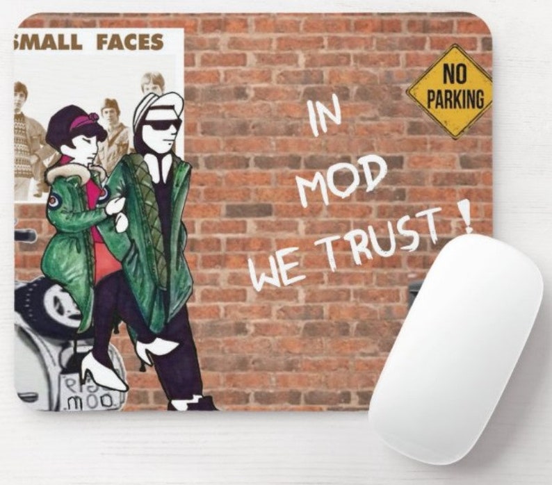 May include: A mouse pad with a brick wall background and a cartoon illustration of two people on a scooter. The text "In Mod We Trust!" is written on the wall in white paint. A yellow sign with the text "No Parking" is in the upper right corner of the image.