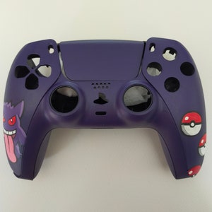 May include: A purple PlayStation 5 controller with a custom design featuring Pokemon characters. The controller has a Ghost-type Pokemon with a purple and red design on the left side and a Pokeball on the right side.