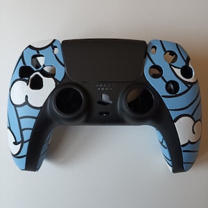 May include: A black PlayStation 5 controller with a blue and white custom design. The design features a cloud pattern with black outlines.