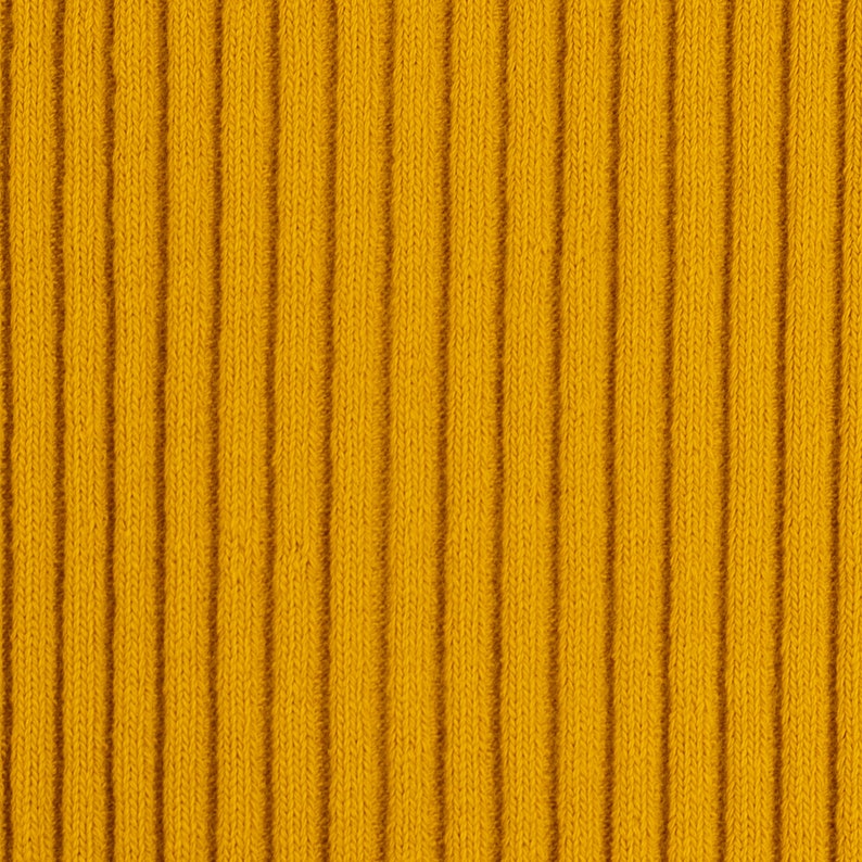 Peut inclure: Un gros plan sur un tissu en maille c&ocirc;tel&eacute;e jaune. Le tissu a une texture verticale.