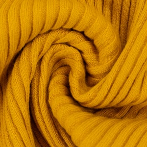 Peut inclure: Gros plan sur un tissu en maille c&ocirc;tel&eacute;e jaune doux. Le tissu est pli&eacute; et tordu, cr&eacute;ant un motif textur&eacute; et abstrait.