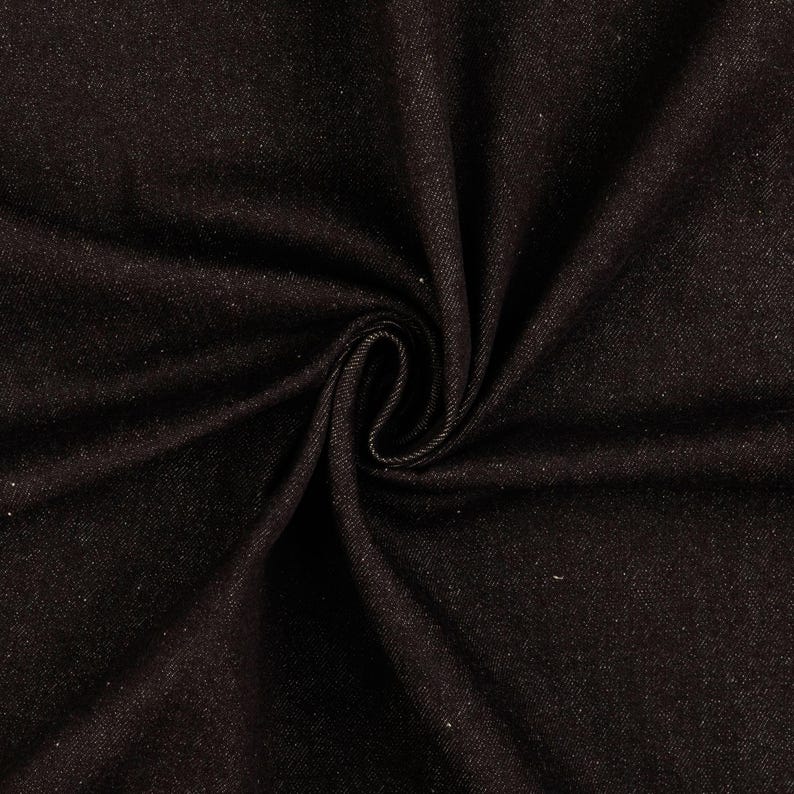 May include: Close-up of dark brown denim fabric with a subtle sheen. The fabric is swirled, creating a spiral pattern in the center. The texture appears soft and slightly textured, suitable for various apparel projects.
