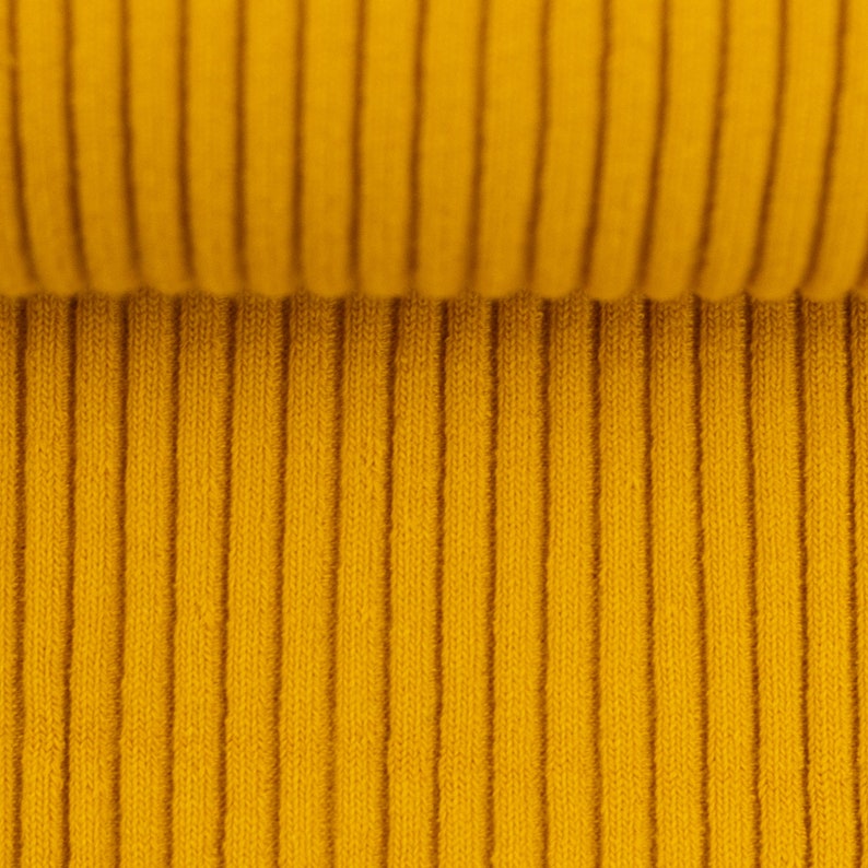 Peut inclure: Gros plan sur un tissu c&ocirc;tel&eacute; jaune. Le tissu a une texture verticale.