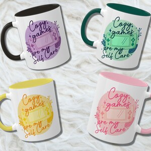 May include: Four different coloured mugs with a design of a video game console and the text "Cozy games are my self care". The mugs have a white background and a coloured rim.
