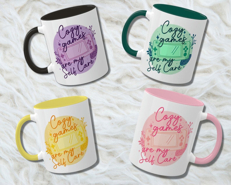 May include: Four different coloured mugs with a design of a video game console and the text "Cozy games are my self care". The mugs have a white background and a coloured rim.