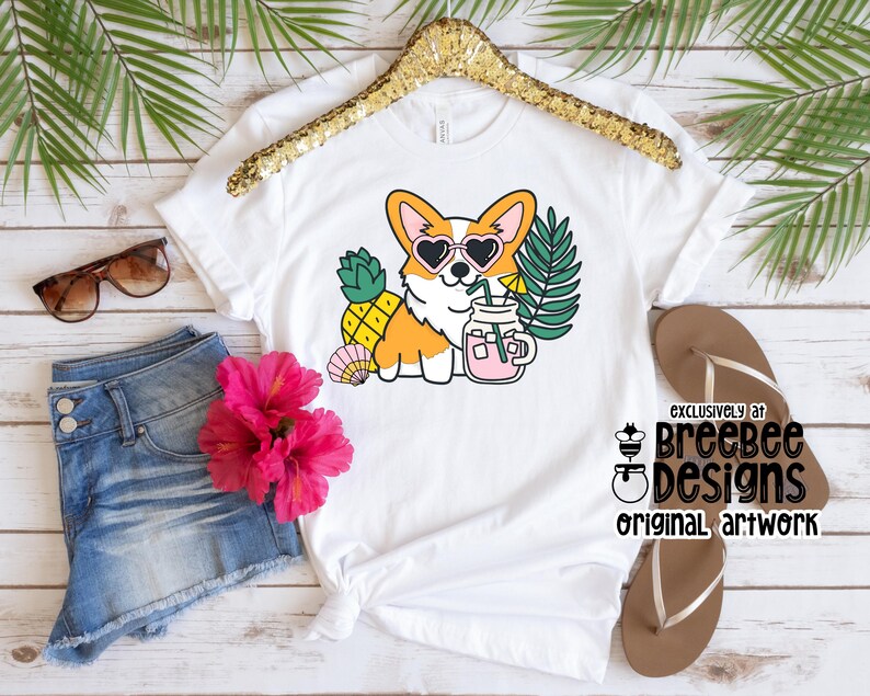 May include: White t-shirt with a cartoon image of a corgi wearing sunglasses and holding a pineapple and a glass of pink lemonade. The text "Exclusively at Breebee Designs Original Artwork" is printed on the bottom right corner of the shirt.