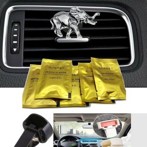 May include: A set of car air fresheners with a silver elephant charm. The air fresheners are in gold foil packets with Chinese text and English text that says "Peach Flavor", "Lemon", "Lavender", and "Floral Fine". The image also shows two black plastic car vent clips.