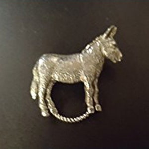 Puede incluir: Una figurita de burro de plata con una superficie texturizada detallada.