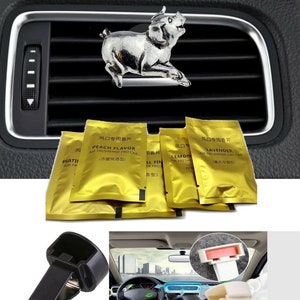 Pode incluir: Um conjunto de cinco aromatizantes de carro em sacos de folha de ouro com diferentes aromas: Peach Flavor, Lemon, Lavender e dois outros em caracteres chineses. Os sacos são exibidos em uma ventilação de carro com uma figura de porco de prata. Também são exibidos dois clipes de ventilação de carro de plástico preto.