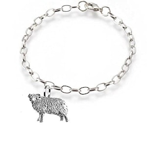 Puede incluir: Un brazalete de cadena de plata con un dije de plata de una oveja. El dije es detallado y realista.