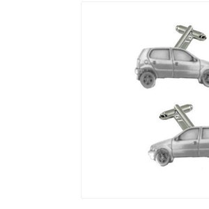 Könnte beinhalten: Ein Paar silberne Manschettenknöpfe in Form eines Kleinwagens. Das Auto ist ein Fließheck mit vier Türen und einer silbernen Oberfläche.