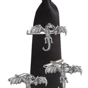 May include: A black striped tie with a silver dragon tie clip and a pair of silver dragon cufflinks.