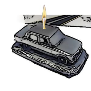 Puede incluir: Una vela de coche negro con una mecha encendida. El coche está sobre una base negra.