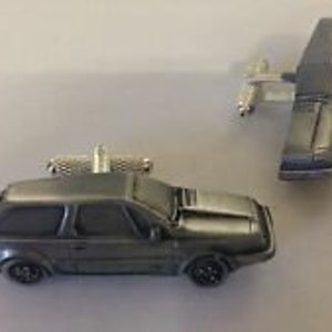 Op de afbeelding: Een paar zilveren manchetknopen in de vorm van een grijze Volvo stationwagen uit de jaren 1980.