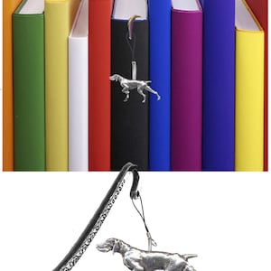 May include: A silver bookmark with a detailed design and a dangling charm of a silver German Shorthaired Pointer dog. The bookmark is shown against a background of colorful book spines.
