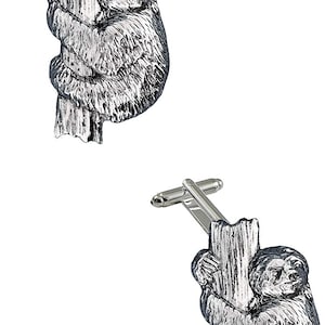 Könnte beinhalten: Ein Paar silberne Manschettenknöpfe mit einem Faultier, das an einem Baumzweig hängt. Das Faultier ist realistisch dargestellt mit detailliertem Fell und Gesichtszügen.