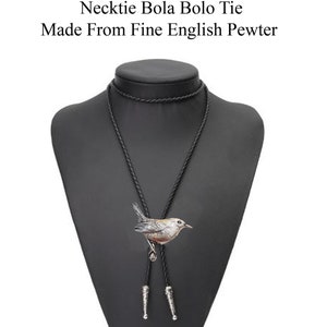 May include: A black bolo tie with a silver bird pendant. The bird is perched on a branch and has brown and white feathers. The tie is on a black mannequin.