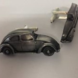 Puede incluir: Un par de gemelos de plata con forma de un clásico Volkswagen Beetle.