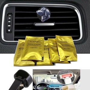 May include: A set of car vent clips with a black and white dog air freshener. The air fresheners are in gold foil packets with Chinese text and English text that says "Peach Flavor", "Lavender", and "Lemon".