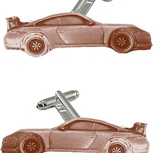 May include: A pair of silver cufflinks with a brown car design. The car is a sports car with a spoiler and large wheels.