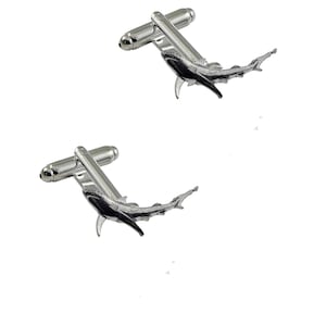 May include: A pair of silver cufflinks featuring a detailed hammerhead shark design.