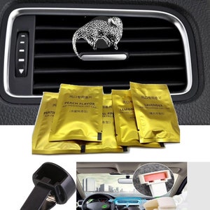May include: A set of five gold car air fresheners with different scents, including peach, lavender, and lemon. The air fresheners are packaged in individual pouches with Chinese text. Two black plastic car vent clips are also included.
