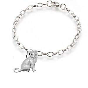 Puede incluir: Una pulsera plateada con un diseño de eslabones de cadena. Un dije detallado de un gato sentado está unido a la pulsera. El dije de gato es plateado y tiene una superficie texturizada.