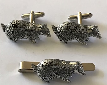 May include: A set of silver badger cufflinks and a tie clip. The badger is depicted in a walking pose with a detailed textured surface.